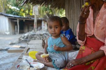 A young girl eating a meal in timor-leste