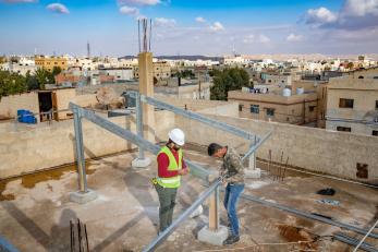 Construction workers on a rooftop in amman, jordan.