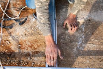 Construction worker's hands while installing equipment.