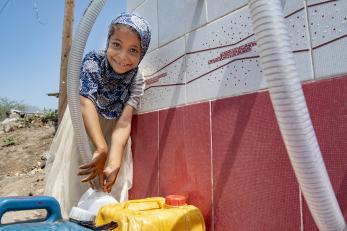 Yemeni girl gathers water at a mercy corps pump.