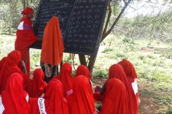 A group of young people listen during an education program in kenya.