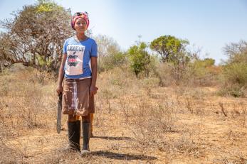 Keynan woman stands in an open space.