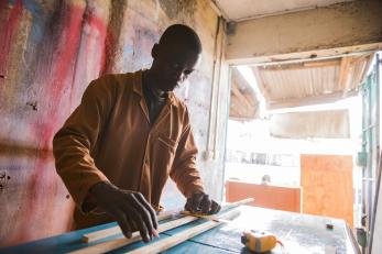 Ad adult carpenter measures wood to build a cabinet