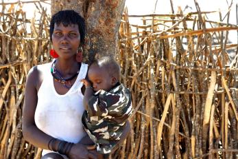 An adult carries a small child in uganda. 