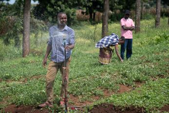 Brian mouti watering crops with a solar-powered water pump.