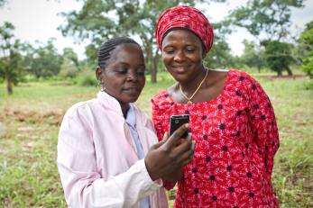 Two people looking at a mobile phone.