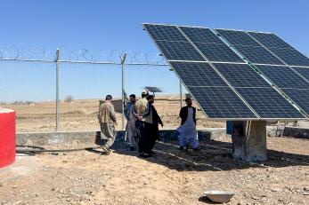 People gather around a solar panel