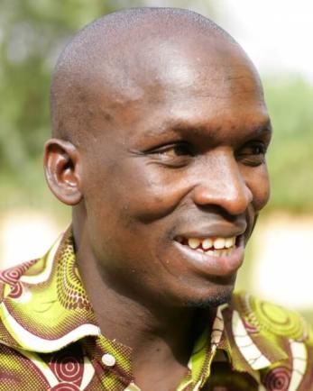 Smiling man in green and maroon patterned shirt