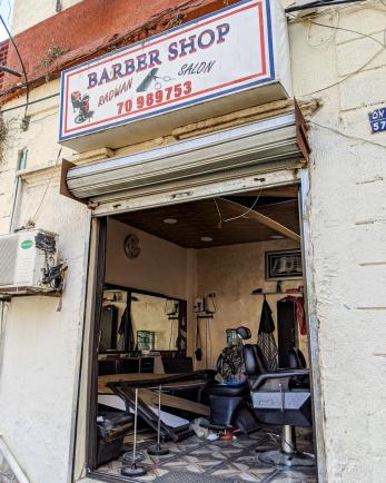 The exterior of a barber shop in lebanon with collapsed ceiling, broken fixtures, and debris.