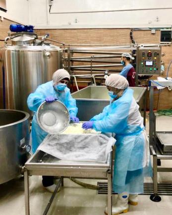 Two people working in protective gear.