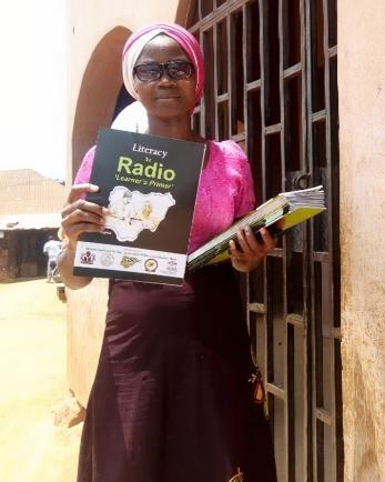 Learning center facilitator chikodi anyadiegwu with “literacy by radio” workbooks used in bwari-federal capital territory, nigeria.