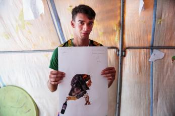 A young man pictured holding his collage.