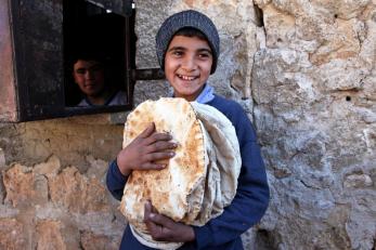 A young boy in Syria holding fresh bread