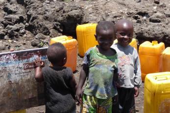 Image of three young boys with yellow water containers