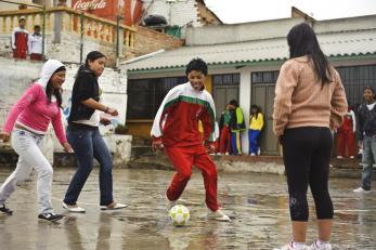 Colombian children playing soccer in the rain