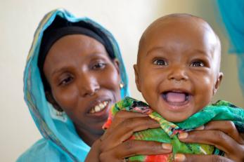 Close up of a smiling baby with mother