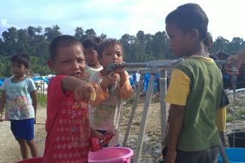 Children in the camp at KM 37 collecting water. Photo: Sara Velasquez/Mercy Corps