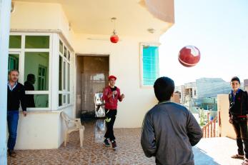 Boys on a patio playing with a soccer ball