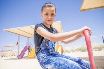 8-year-old Majeda, a Syrian refugee, playing on a playground