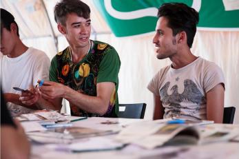 Two young men seated side by side at a table