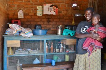 Grace stands with her daughter in her retail shop, now the only dealer of high-quality seeds in her rural area in northern Uganda. Photo: Caitlin Turnbull/Mercy Corps