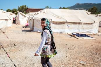 Girl in Greece walking near white tents