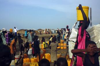 People gathered around water and supplies