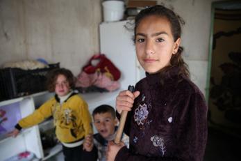 Girl in Iraq holding broom