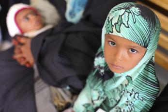 Girl next to a person holding a young child