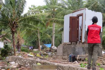 Mercy corps employee surveying damage