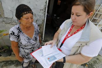 Mercy Corps employee working with woman aid recipient. 