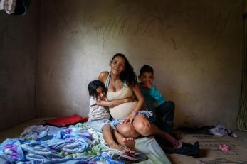 Woman with two children sitting on floor with blankets