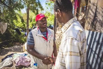 Mercy Corps employee shaking hands with Haitian hurricane victim