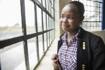 Kenya woman smiling and looking out the window