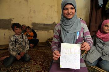 Syrian refugee child displaying her artwork.