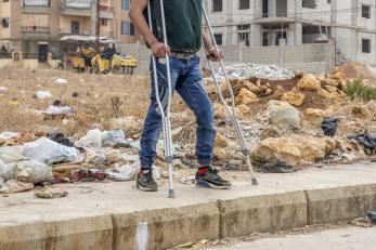 disabled individual standing in front of empty lot.