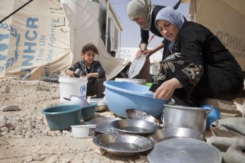Women and girls washing dishes in a refugee camp