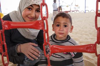 Nour and her younger brother at a playground