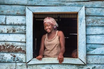 Woman smiling, at her window