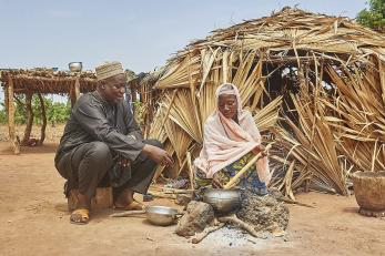 man and woman cooking outside of their home