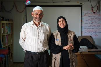 A man and woman smile while standing side by side