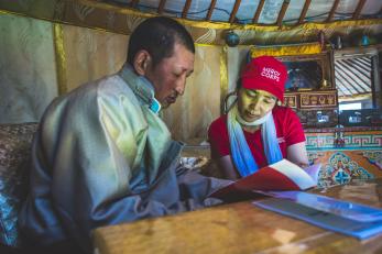 mercy corp team member reviewing materials with community member