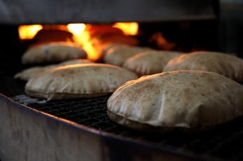 Round bread bakes in an oven in syria