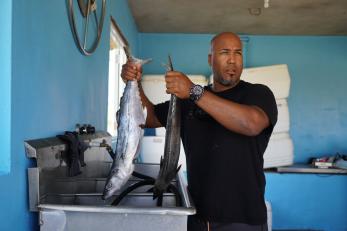 A fisherman in puerto rico cleans tuna fish in his garage fish work area. photo: angel valentin for mercy corps
