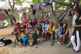 A group of refugees and mercy corps team members in a yard