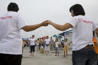 two mercy corps team members holding hands