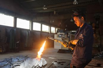 young man working with blow torch