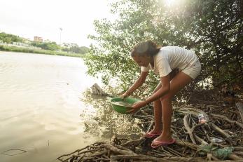 A girl gets water from a stream in colombia