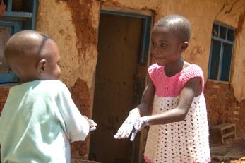 Christine, 6, and her little brother Gabriel, 3, practice their hand washing techniques. Photo: Rudy Nkombo/Mercy Corps