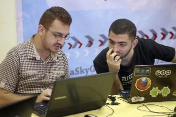 two men working together on laptops